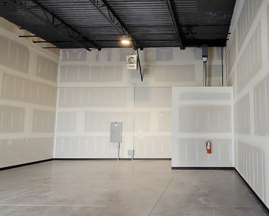 A flexible workshop space featuring shelves, equipment, and tools.